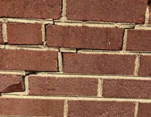 Close-up of staircase or step cracks in a brick foundation wall, indicating potential structural settling issues in Culpeper, VA.