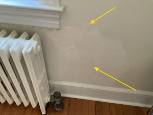 Home inspection photo highlighting poorly finished DIY drywall repairs and historical moisture patches on an interior wall, Warrenton, VA.